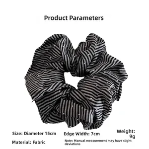 Detailed view of black and white striped scrunchie with sparkling rhinestone embellishments