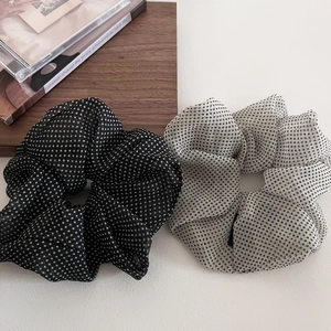 Detailed view of polka dot mesh hair scrunchies in black and white sheer fabric
