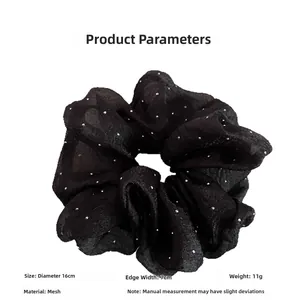 Detail view of a black 16cm oversized seersucker scrunchie with silver star dots