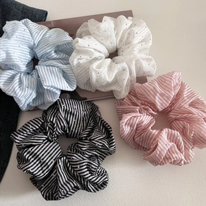 Detail of striped fabric scrunchies with small sparkling rhinestones in four colors