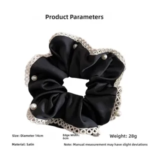 Detail showing black satin scrunchie with white lace trim and pearls, 14cm diameter