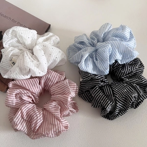 Close-up of striped scrunchies with glitter rhinestones in blue, pink, and black