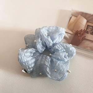 Vue détaillée du chouchou en seersucker bleu clair avec perles blanches et étiquette