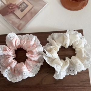 Scrunchies in pizzo floreale rosa e beige su vassoio di legno con design romantico