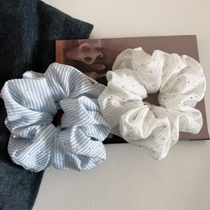 Elegant striped hair scrunchies with rhinestones on a white textured desk background