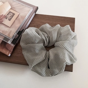 Detail of French mesh polka dot hair scrunchie on vintage wood tray with minimalist style