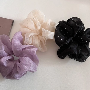 Detail of three oversized seersucker hair scrunchies with shimmering silver rhinestones