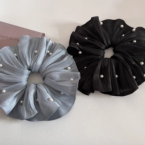 Gros plan sur des chouchous plissés élégants avec perles blanches en noir et gris argenté