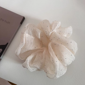 Detail of a fluffy cream white seersucker hair scrunchie with sparkling silver rhinestones