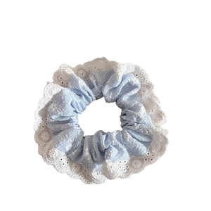 Elastico per capelli floreale azzurro con bordo in pizzo bianco su sfondo bianco