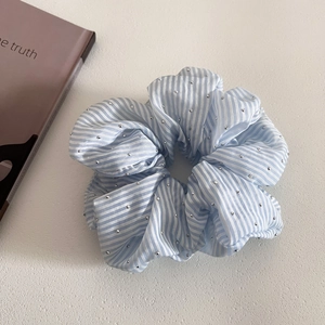 Detailed texture of blue striped scrunchie with sparkling rhinestones decoration