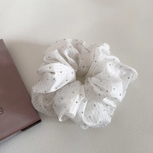 Detail of white striped scrunchie with sparkling rhinestones and elegant fabric texture