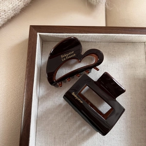 Brown acetate hair claw clips set including heart and rectangular shapes on a tray