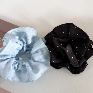 Detail of light blue and black scrunchies with heart patterns and textured fabric