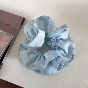 Light blue double-layered scrunchie with dark blue heart patterns on a white background