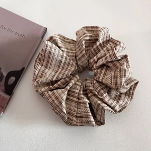 Detail of checkered plaid scrunchie with white lace trim and vintage fabric texture