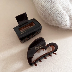 Detail of dark brown tortoiseshell acetate hair claws with heart and geometric shapes