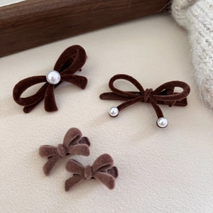 Close-up of four brown velvet bow hair clips with pearls and autumn aesthetic details