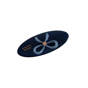 Oval acetic acid hair clip in navy blue with light blue bow and sparkling amber diamond
