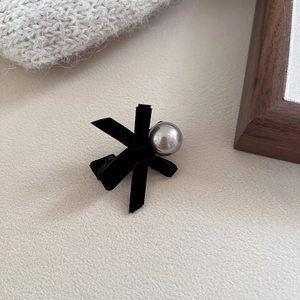 Close-up of black velvet bow hair clip with a metallic silver pearl bead detail