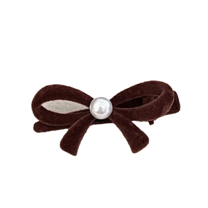 Elegant red velvet bow hair clip with a central pearl embellishment on white background