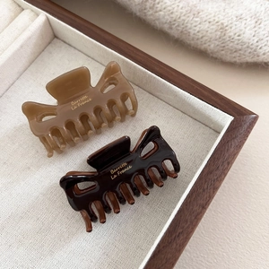 Détail de pinces à cheveux en résine brillante marron caramel et café avec lettrage