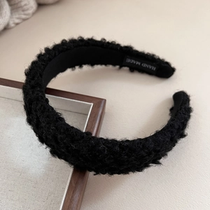 Detailed view of handmade black faux shearling headband with visible plush texture
