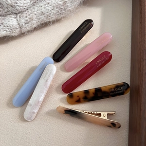 Close-up of handmade acetate hair clips in marble and tortoiseshell patterns