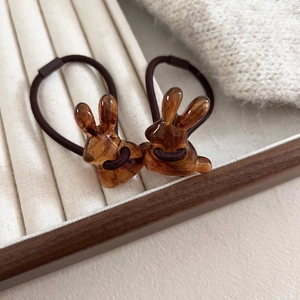 Set of two amber resin rabbit hair ties with high elastic brown bands in a wooden tray
