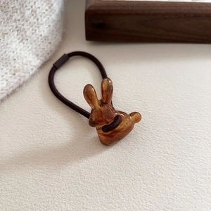 Cute amber resin rabbit hair tie with high elastic brown band on minimalist background