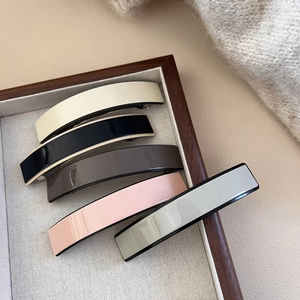 Set of 5 elegant acetate spring hair clips in neutral colors on a wooden tray