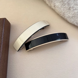 Minimalist acetate spring hair clips in cream and black with a glossy finish