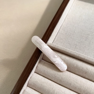 Detail of pink acetate oval hair clip with France Handmade lettering on fabric tray