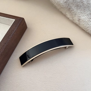 Elegant acetate spring hair clip with minimalist black and cream white contrast design