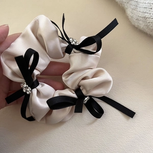 Chouchou élégant en satin beige orné de nœuds noirs et de strass brillants pour cheveux