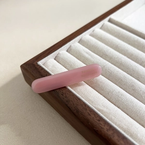 Detail of pink acetate oval hair clip with gold France Handmade lettering on tray