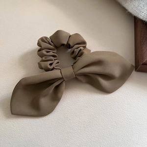 Detailed view of the dark brown scrunchie with twill fabric texture and ribbon bow