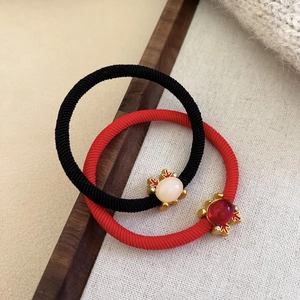 Red and black elastic hair ties with gold-plated animal charms and inlaid crystals