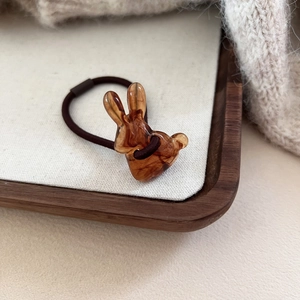 Élastique à cheveux marron avec breloque lapin en résine ambre sur plateau