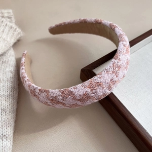 Detailed texture of pink and white tweed headband with thick sponge padding and soft fabric