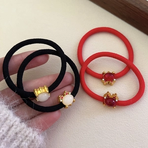 Detailed macro view of festive braided elastic hair ties with gold metallic ornaments