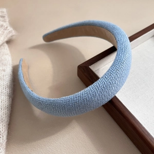 Close-up of light blue braided fabric headband with thick sponge and textured woven surface