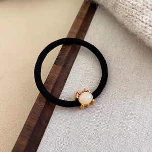Detail of high elastic hair tie with golden reindeer antler and white resin stone