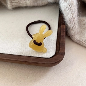 Détail d'un élastique à cheveux lapin jaune mignon avec cordon élastique sur un plateau