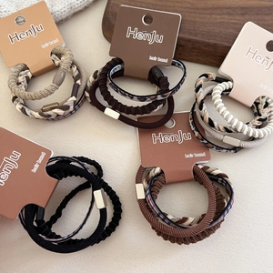 Dettaglio di elastici per capelli marroni e leopardati con accenti in metallo