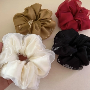 Détail de quatre chouchous géants en organza avec perles blanches en diverses couleurs