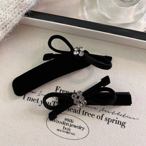 Macro view of black velvet bow hair clips with sparkly rhinestone center decoration