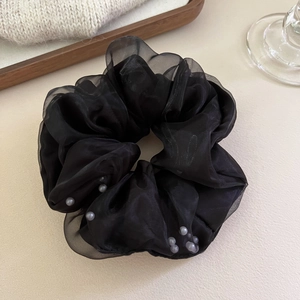 Détail du chouchou en organza noir avec perles grises montrant la texture douce du mesh