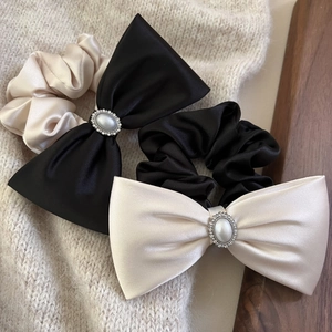 Detail von Satin-Haargummis mit Perlen und Strass auf einem gemütlichen Strickhintergrund