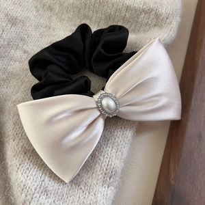Eleganter Satin-Haargummi mit Schleife, Perle und Strass auf Strickhintergrund